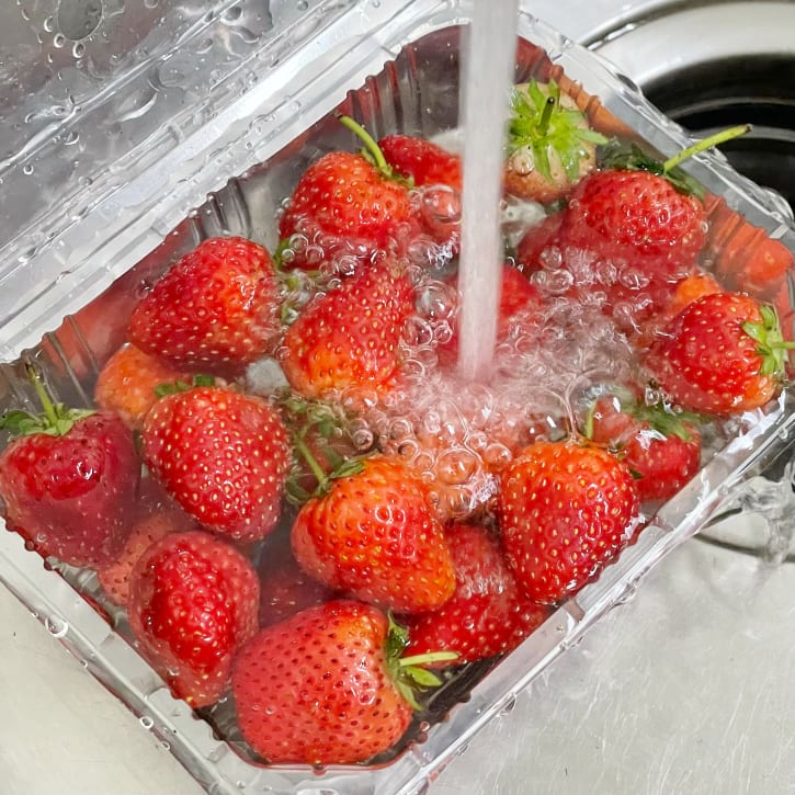 Rinsing Strawberries Under Running Water