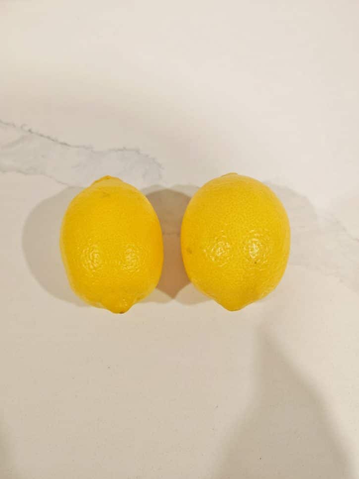 Two Lemons Side By Side On Table