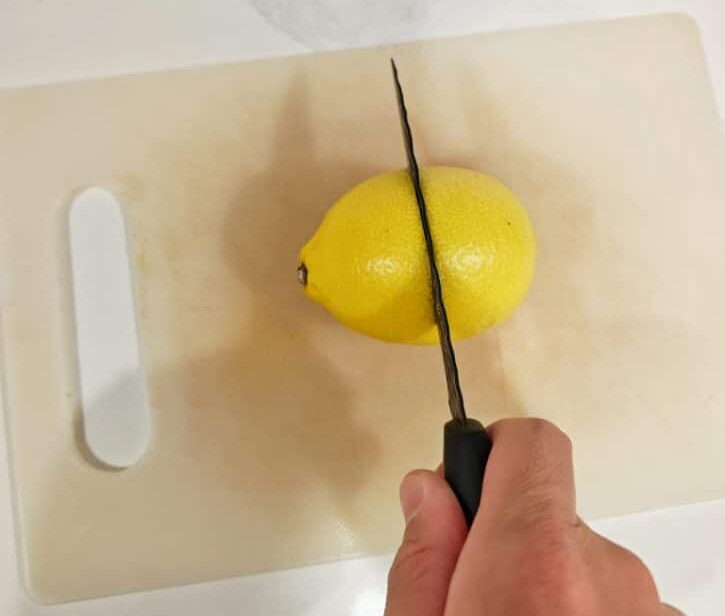 Cutting Lemon Horizontally On Cutting Board