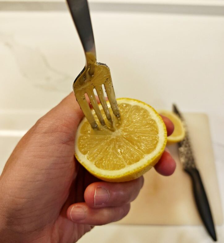 Fork Pressing Lemon Half To Release Juice