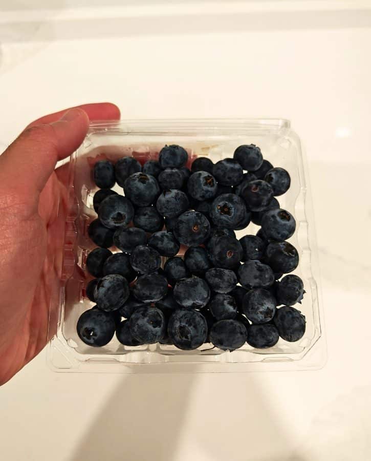 Fresh Blueberries In Hand Holding Container